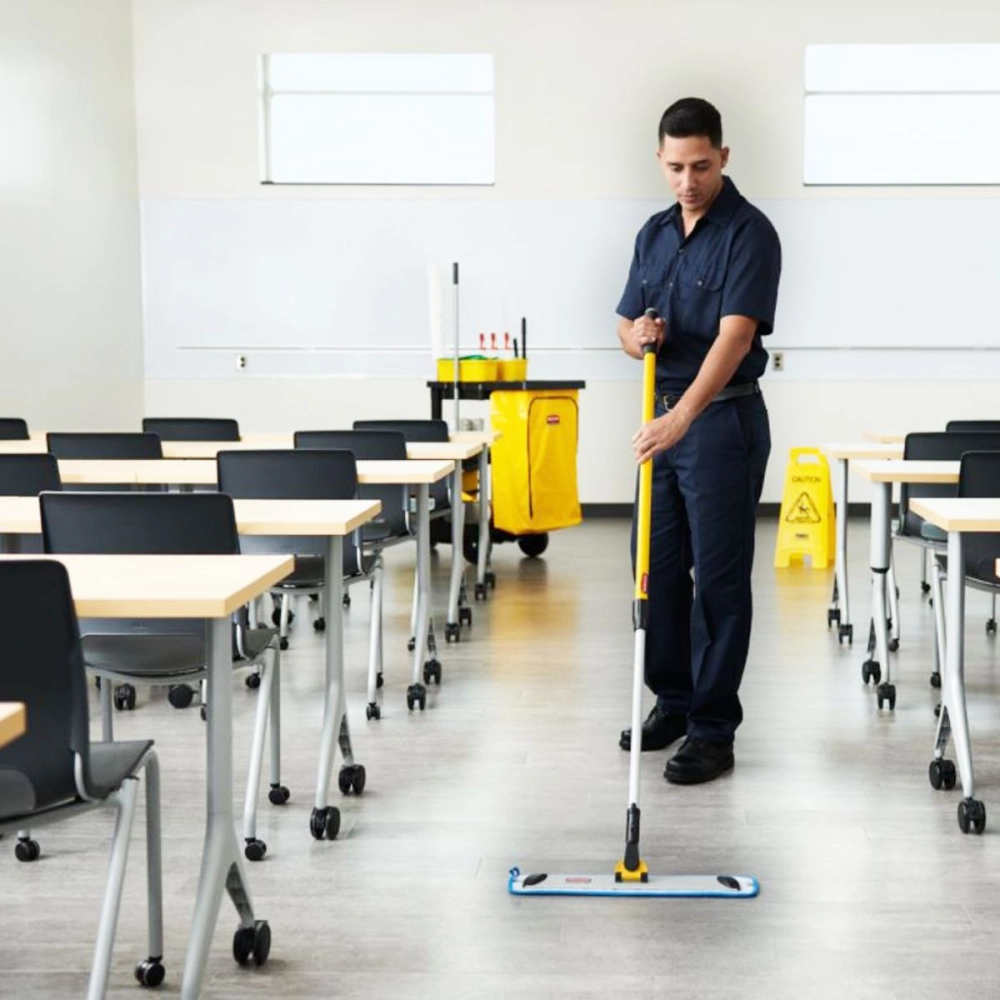 Experienced commercial cleaner disinfecting high-touch office surfaces with organized professional equipment