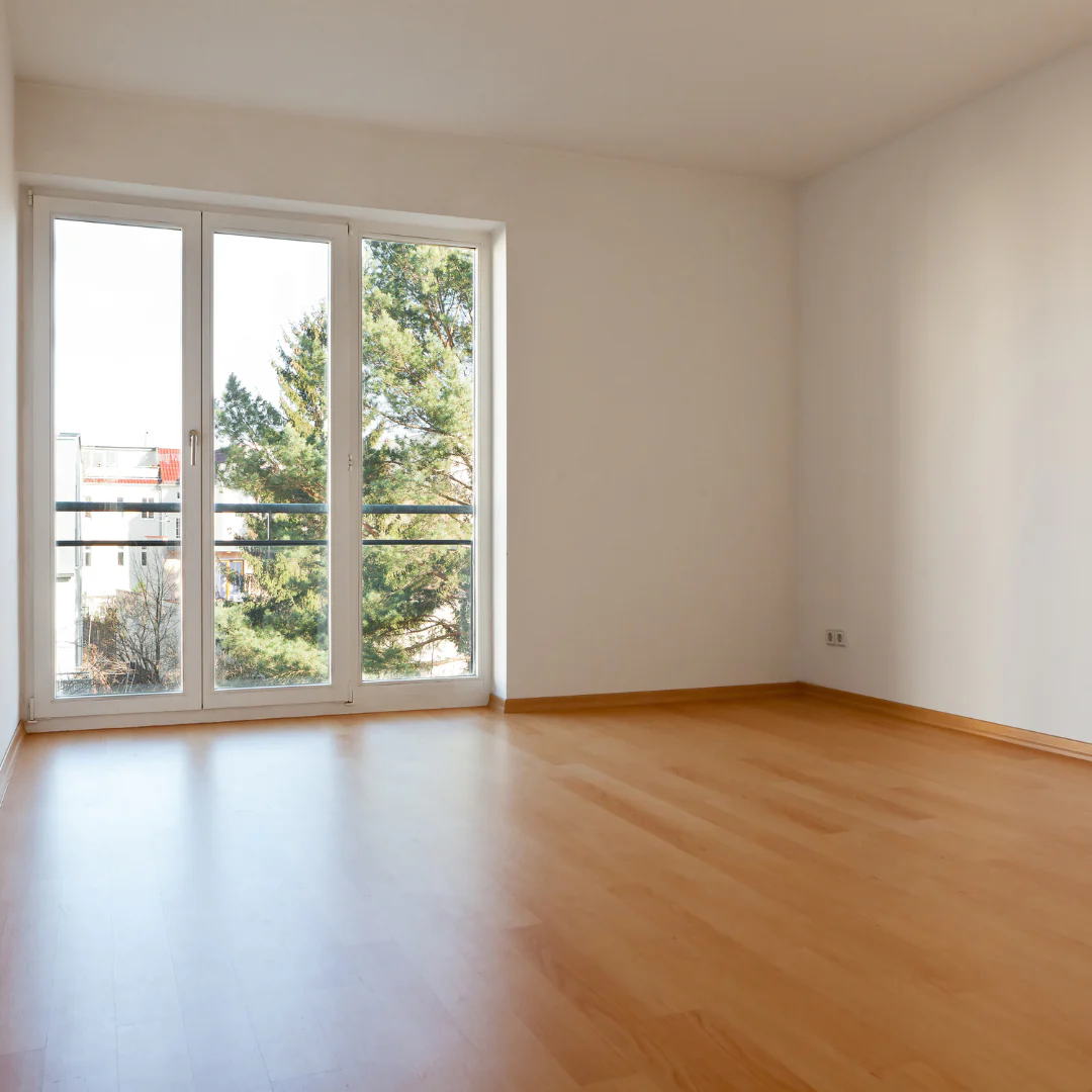 Cleaner scrubbing empty kitchen cabinets and counters before family moves into new home