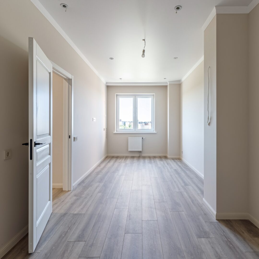 Cleaner scrubbing empty kitchen cabinets and counters before family moves into new home