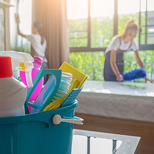 Professional cleaner carefully sanitizing bathroom surfaces with organized tools and precise technique