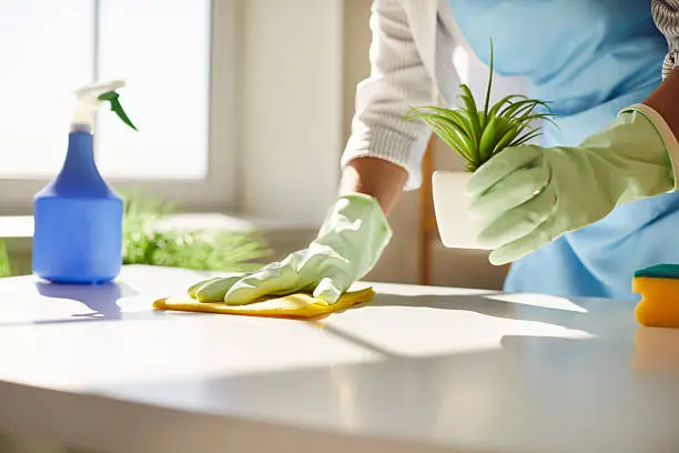 Commercial Office Cleaning Service in Estero - FL cleaning a conference room table before morning meetings, Commercial Office Cleaning Service team sanitizing desks inside a Bonita Springs - FL office suite